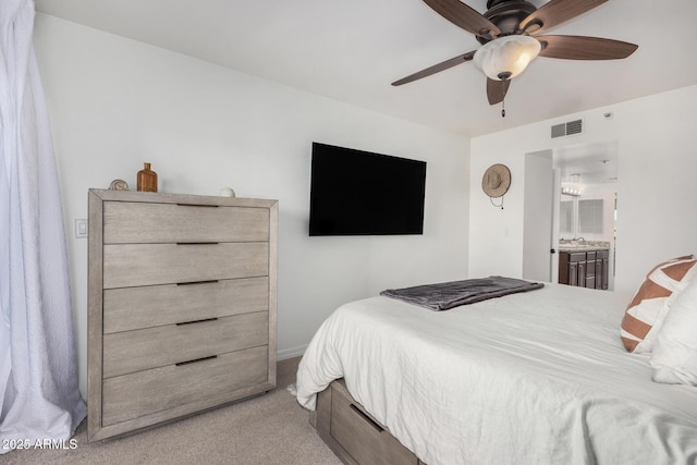 carpeted bedroom featuring ceiling fan, ensuite bathroom, and sink