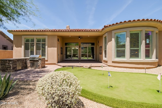 32731 N 74th Way, Scottsdale, AZ 85266 - back of property featuring a patio, stucco siding, an area to practice putting, an outdoor kitchen, and a tiled roof