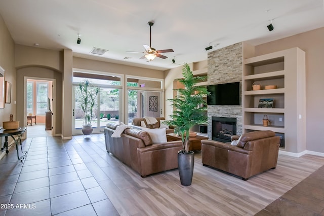 32731 N 74th Way, Scottsdale, AZ 85266 - living area with ceiling fan, a fireplace, baseboards, built in shelves, and light wood finished floors