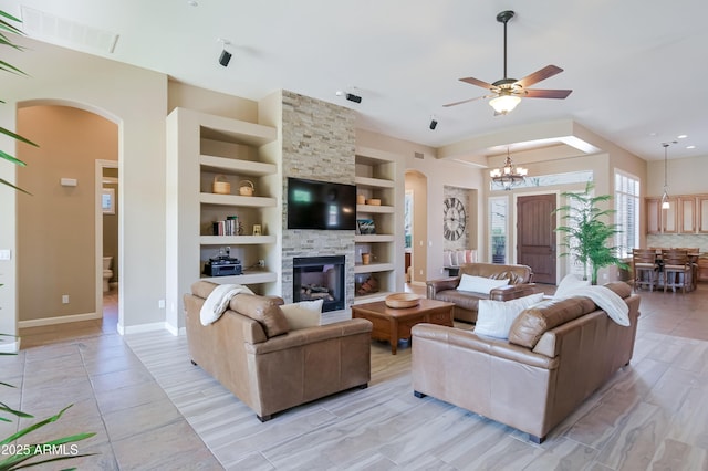 32731 N 74th Way, Scottsdale, AZ 85266 - living room featuring built in shelves, arched walkways, a fireplace, baseboards, and a chandelier