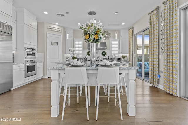 kitchen featuring white cabinetry and a kitchen island with sink