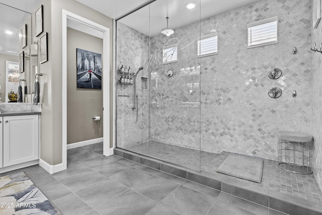 bathroom featuring tiled shower, vanity, and tile patterned floors