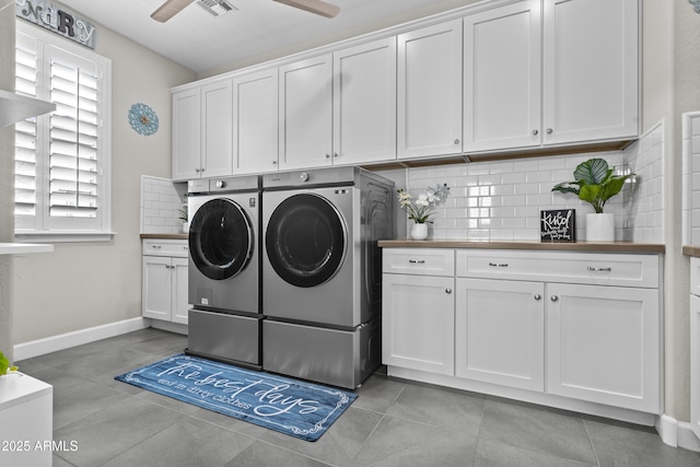 clothes washing area with cabinets, washing machine and dryer, light tile patterned flooring, and ceiling fan