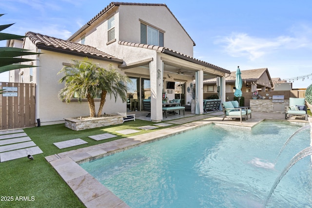 rear view of property with a patio area, ceiling fan, and an outdoor kitchen