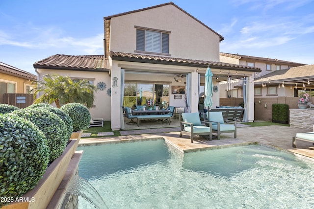 back of property with ceiling fan, a fenced in pool, and a patio