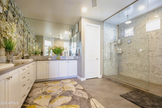 bathroom featuring ceiling fan, vanity, tile patterned flooring, and a tile shower