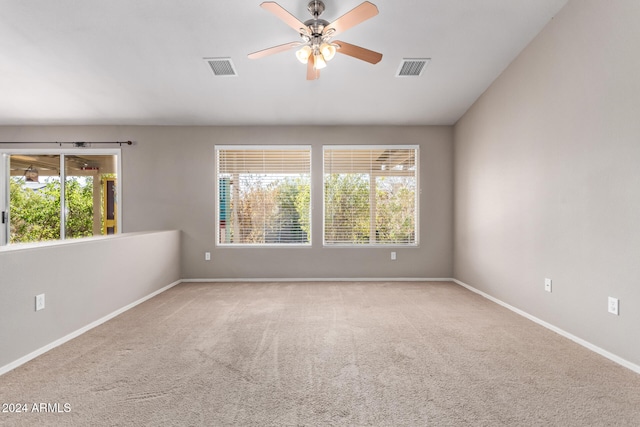 carpeted spare room featuring ceiling fan and plenty of natural light