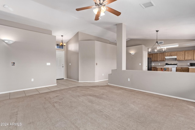 unfurnished living room featuring ceiling fan with notable chandelier, light colored carpet, and vaulted ceiling