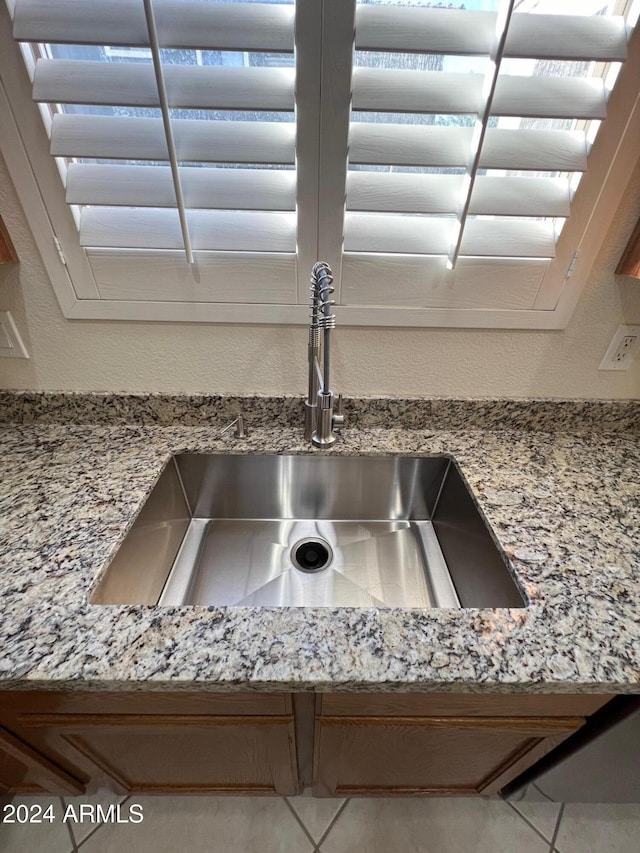 interior details with light stone countertops and sink