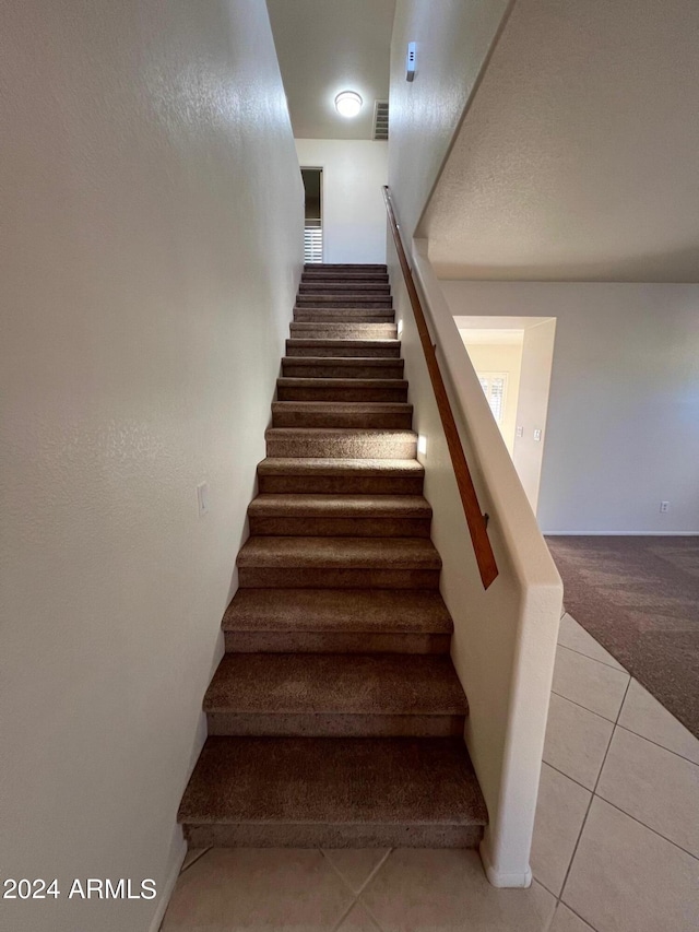 stairway with tile patterned flooring