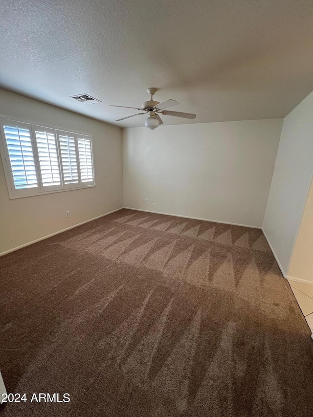 unfurnished room featuring a textured ceiling, carpet floors, and ceiling fan