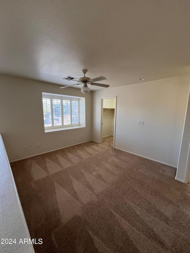 spare room featuring ceiling fan, a textured ceiling, and carpet floors