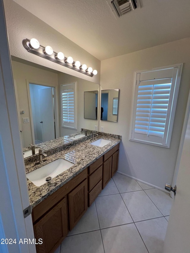 bathroom with vanity, a textured ceiling, and tile patterned flooring