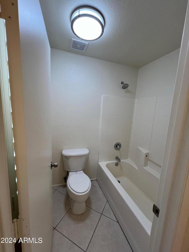 bathroom with bathtub / shower combination, a textured ceiling, toilet, and tile patterned flooring