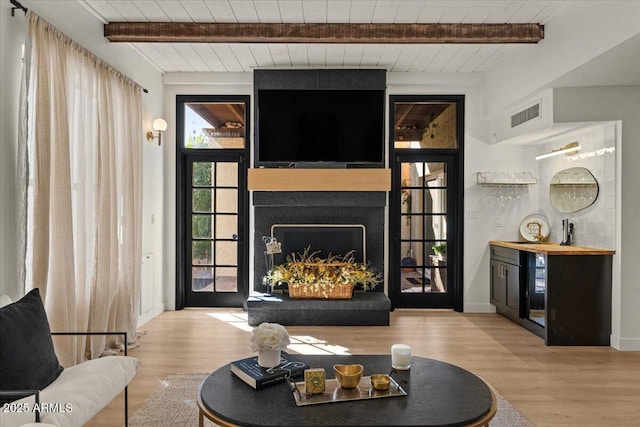 living room with light hardwood / wood-style flooring, beam ceiling, wood ceiling, and wine cooler