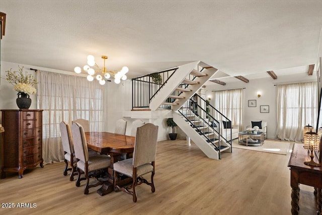 dining room with hardwood / wood-style floors, a textured ceiling, and a notable chandelier