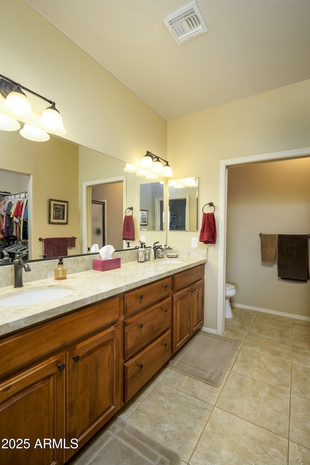 full bath featuring double vanity, visible vents, tile patterned floors, and a sink