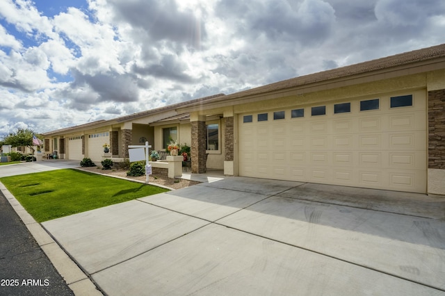 view of front of house featuring stucco siding, driveway, stone siding, a front yard, and a garage