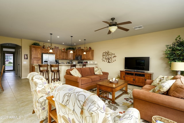 living area with visible vents, recessed lighting, arched walkways, light tile patterned floors, and ceiling fan