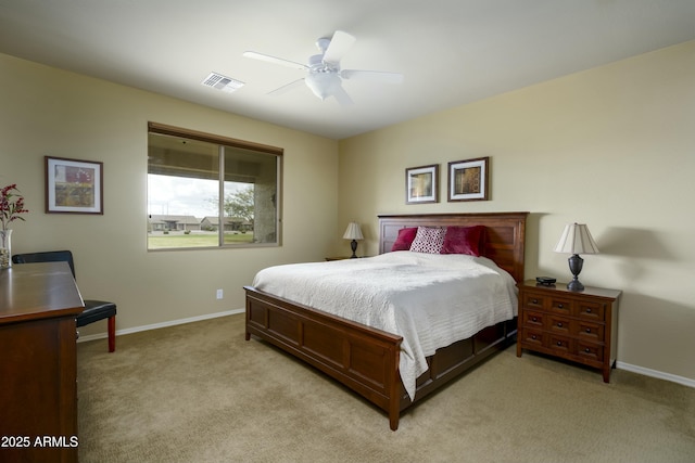 bedroom featuring visible vents, baseboards, light colored carpet, and a ceiling fan