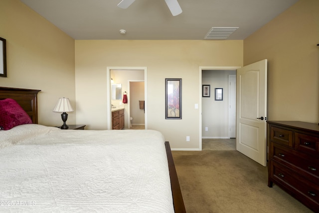 carpeted bedroom with visible vents, connected bathroom, baseboards, and a ceiling fan