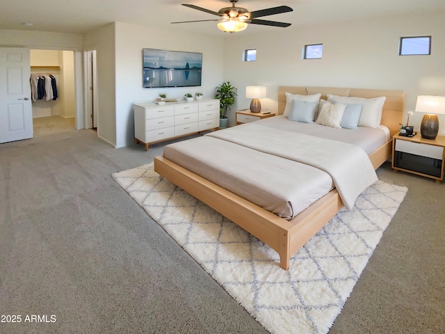 bedroom with a spacious closet, light carpet, ceiling fan, a closet, and multiple windows