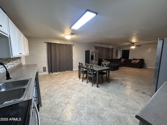 dining room featuring baseboards, visible vents, and ceiling fan