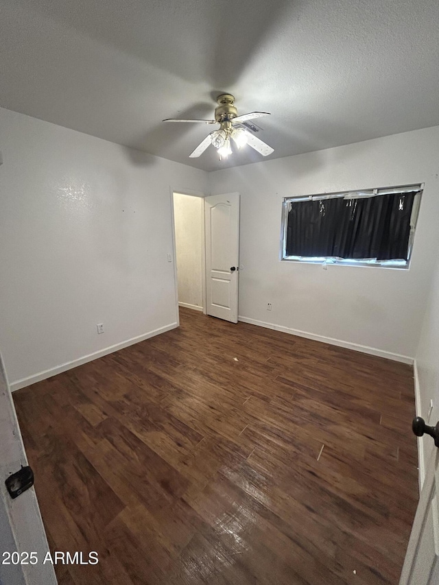 unfurnished room featuring ceiling fan, a textured ceiling, baseboards, and wood finished floors