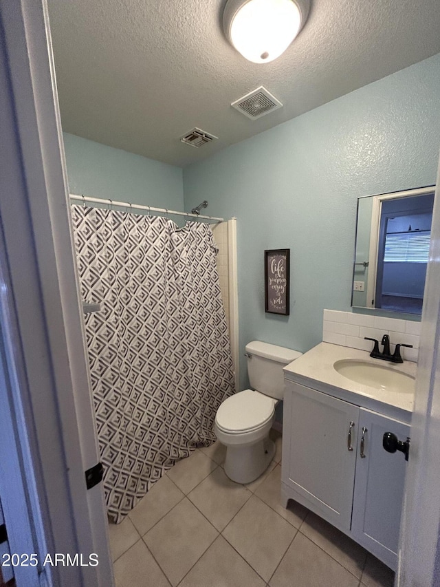 bathroom with toilet, vanity, visible vents, and tile patterned floors