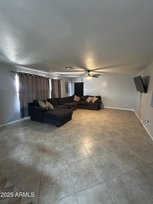 tiled living area with ceiling fan, visible vents, and baseboards