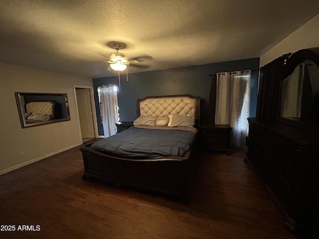 bedroom with a ceiling fan, dark wood-style flooring, a textured ceiling, and baseboards