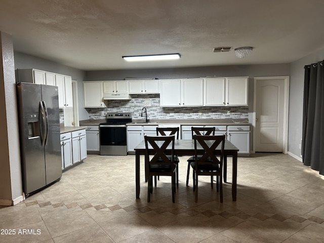 kitchen featuring fridge with ice dispenser, visible vents, decorative backsplash, and stainless steel range with electric cooktop