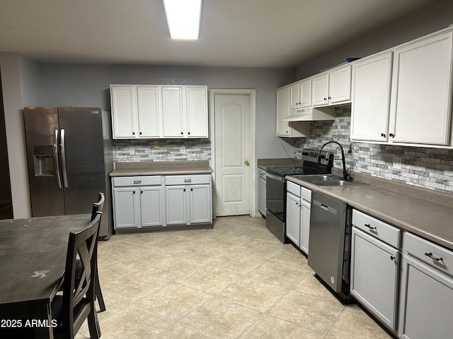 kitchen featuring appliances with stainless steel finishes, backsplash, a sink, and under cabinet range hood