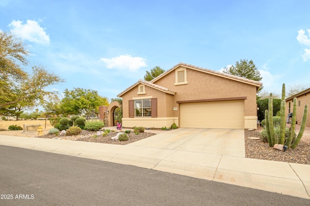 view of front of property featuring a tile roof, stucco siding, concrete driveway, fence, and a garage