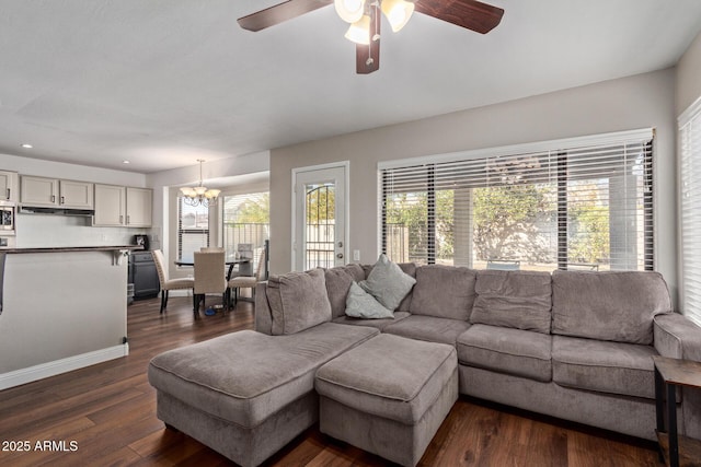 living room featuring ceiling fan with notable chandelier, dark wood-style flooring, and recessed lighting