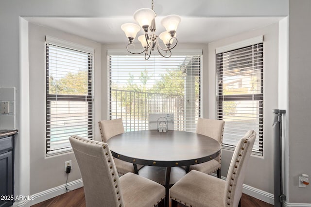 dining space featuring baseboards, dark wood-type flooring, and a notable chandelier