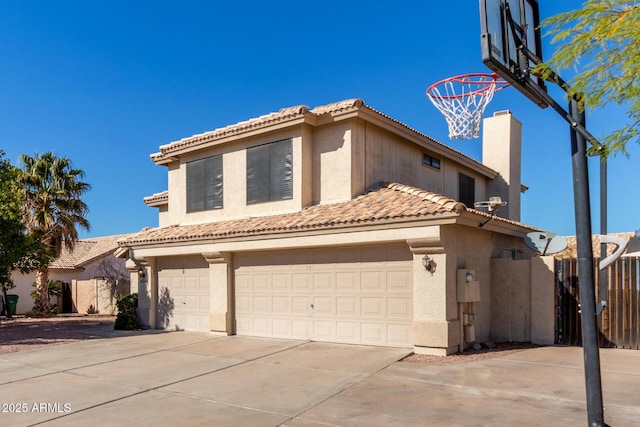 mediterranean / spanish home featuring a tile roof, concrete driveway, and stucco siding