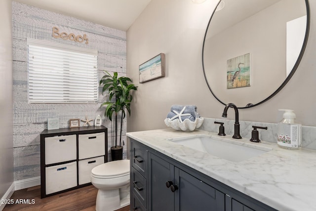 bathroom featuring toilet, wood finished floors, and vanity