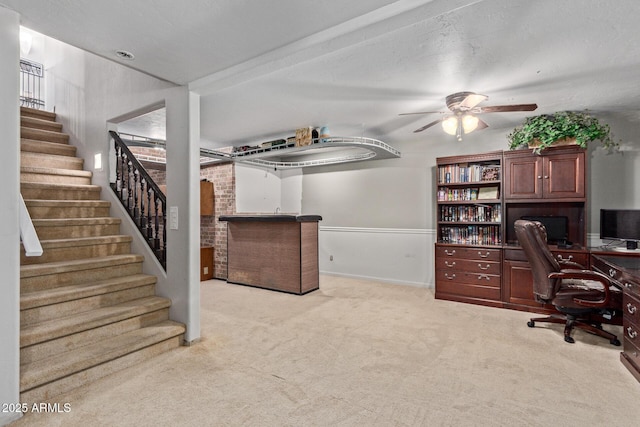 office space featuring a ceiling fan and light colored carpet