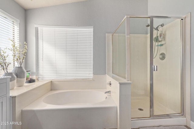 bathroom featuring a shower stall and a bath