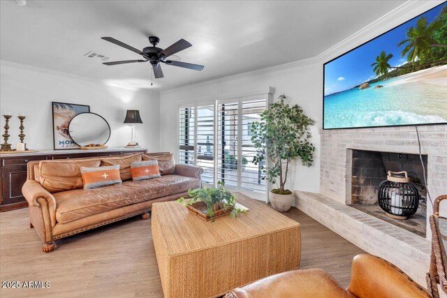 3505 N Miller Rd, Scottsdale, AZ 85251 - living area featuring light wood-style flooring, crown molding, a fireplace, and a ceiling fan