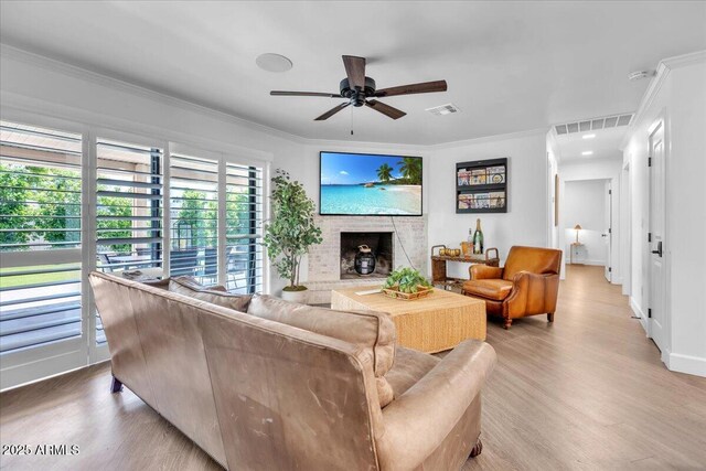 3505 N Miller Rd, Scottsdale, AZ 85251 - living area featuring ornamental molding, a fireplace with raised hearth, light wood finished floors, a ceiling fan, and baseboards