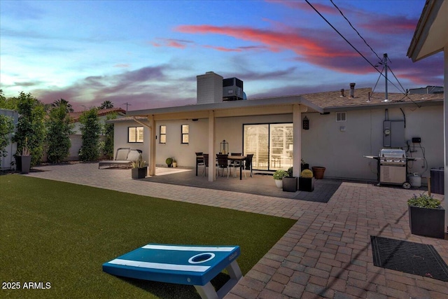 3505 N Miller Rd, Scottsdale, AZ 85251 - rear view of house with stucco siding, a patio area, a chimney, and a lawn