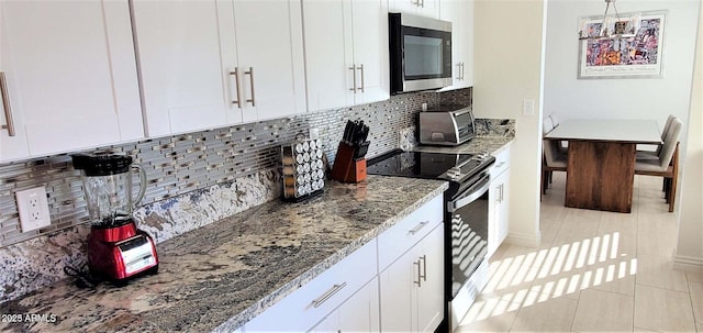 4617 E Emile Zola Ave, Phoenix, AZ 85032 - kitchen featuring stainless steel microwave, electric range, light stone counters, white cabinets, and decorative backsplash