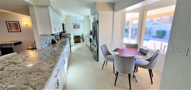 4617 E Emile Zola Ave, Phoenix, AZ 85032 - kitchen featuring stainless steel appliances, light stone counters, white cabinets, and backsplash