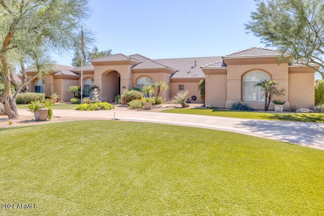 mediterranean / spanish-style house featuring a front lawn