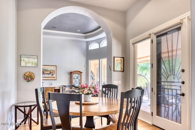 7101 E Berneil Ln, Paradise Valley, AZ 85253 - dining area with plenty of natural light, arched walkways, a high ceiling, light wood-style floors, and a tray ceiling