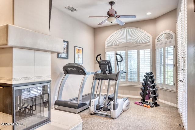 exercise area featuring light carpet and ceiling fan