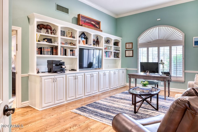 home office with crown molding and light hardwood / wood-style floors