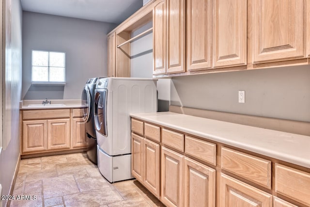 washroom featuring cabinets, washing machine and clothes dryer, and sink